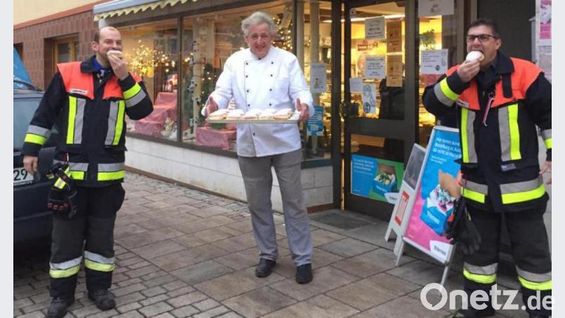 Vorsitzender Thomas Kormann (links) und Kommandant Sven Zocher (rechts) genießen dankbar die süßen Krapfen der Bäckerei Winter. Bild: lei