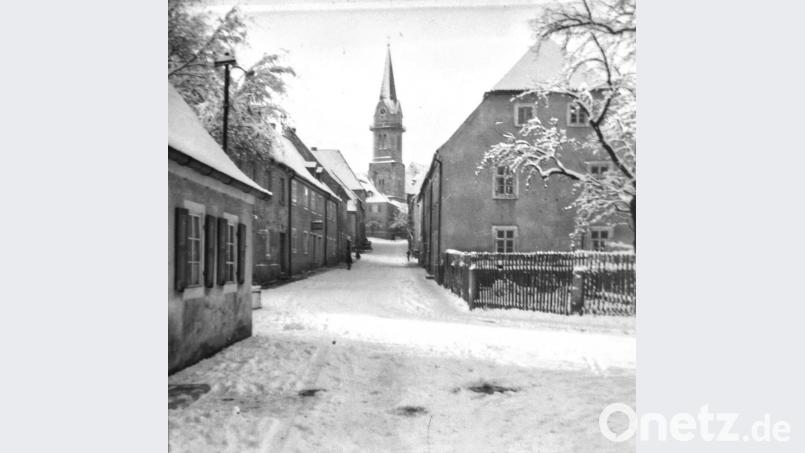 Die Pfarrgasse im Winterkleid mit Blick auf den Marktplatz und auf den Turm der katholischen Pfarrkirche. Das war 1953. Das Anwesen (linke Seite) wurde einige Jahre später aufgestockt. Bild: Robert Müller/exb