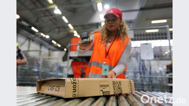 Eine Amazon-Mitarbeitern scannt ein Paket ein. Symbolbild: Ina Fassbender/dpa