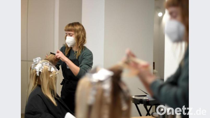 So wird man sich den Friseurbesuch ab dem 1. März vorstellen müssen: Eine Friseurin färbt einer Kundin in ihrem Salon die Haare; beide tragen FFP2-Masken. Bild: Roland Schlager/dpa