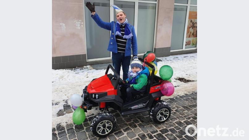 Begleitet von den Helau-Rufen des Präsidenten von &quot;Weiß-Blau Wiesau&quot;, Helmut Gleißner, steuerte Söhnchen Paul den elektrobetriebenen Festwagen über den Marktplatz, damit der Rosenmontags-Umzug nicht ganz ausfällt. Bild: Kathrin Gleißner/exb