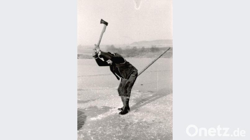Mit einer langstieligen Axt werden auf dem zugefrorenen See Eisplatten herausgeschlagen. Archivbild: lg