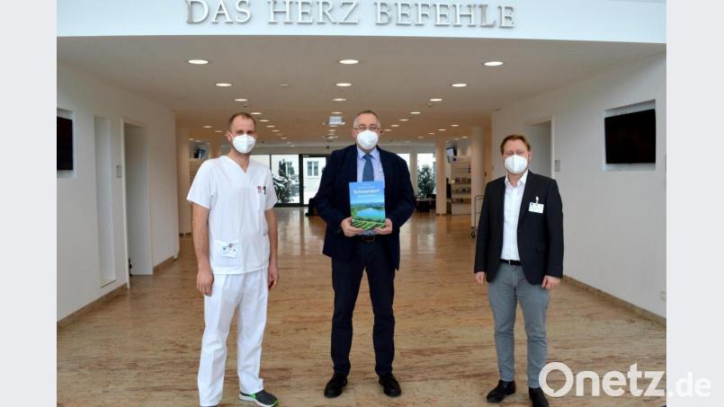 Josef Roidl (Mitte) hat als Dankeschön für die gute medizinische Behandlung und Pflege seiner Mutter auf der Corona-Isolierstation 100 Exemplare des Bildbands an den stellvertretenden Stationsleiter Josef Fischer (links) und Geschäftsführer Dr. Martin Baumann übergeben. Bild: Marion Hausmann/exb