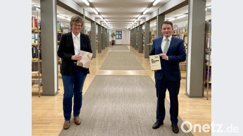 Sabine Guhl, Leiterin der Regionalbibliothek Weiden, freut sich mit Oberbürgermeister Jens Meyer über die längere Gültigkeit der Bibliotheksausweise. Bild: Regionalbibliothek/exb