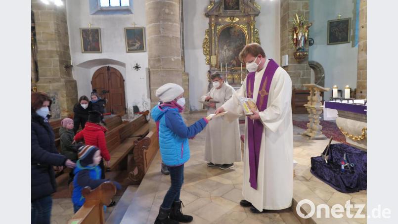 Nach dem Segen erhielt jedes Kind von Stadtpfarrer Thomas Kraus und Gemeindereferent Jochen Gößl (von rechts) ein faltbares Opferkästchen für die Misereor-Spende. Bild: jzk