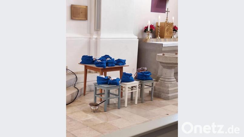 Blaue Leinensäckchen vor dem Taufbecken symbolisieren das Rekordergebnis der Sternsingersammlung zum Beginn der Fastenzeit. Bild: fjo