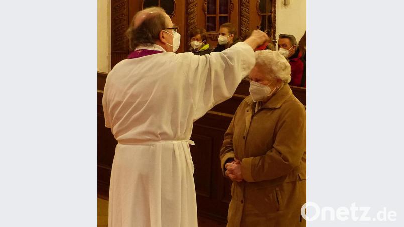 Pater Andreas Hamberger streut die geweihte Asche über die Stirn der Gläubigen. Der Aschermittwoch wird in der Schlammersdorfer Pfarrei in Form eines Bußgottesdienstes gefeiert. Bild: lgc