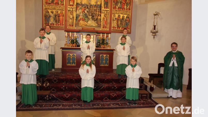 Kaplan Daniel Fenk (rechts), Oberministrant Simon Mehler (hinten rechts) und Ministrant Felix Kohl (hinten links) hießen sechs neue Ministranten (erste und zweite Reihe) willkommen. Bild: kro