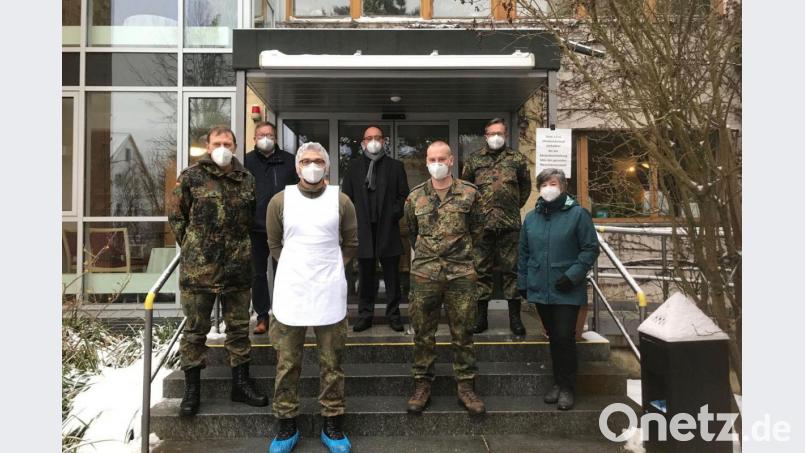 Hauptmann Anton Sertl, Oberbürgermeister Michael Cerny, Heimleiter Marcus Keil, Oberstleutnant Stephan Koller und die Pflegefachberaterin der Führungsgruppe Katastrophenschutz, Birgit Hübner (hinten, von links), mit den diensthabenden Soldaten vor dem Seniorenheim der Diakonie in der Hellstraße in Amberg. Bild: Susanne Schwab/exb