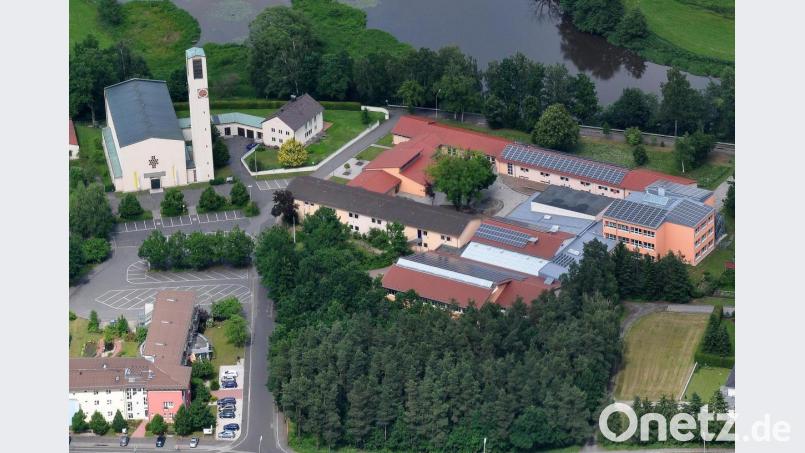 Ein Teil des Wäldchens im Vordergrund wird der neuen Mehrzweckhalle weichen müssen. Die Digitalisierung in der Schule (rechts) schreitet voran. Archivbild: twi