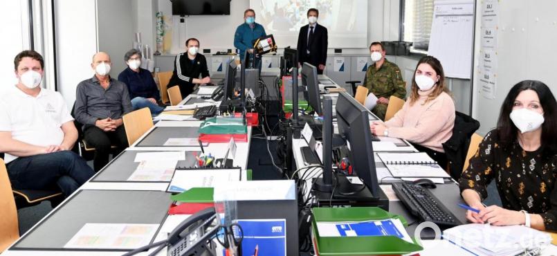 Oberbürgermeister Michael Cerny (stehend, links) bedankt sich beim Einsatzleiter der Führungsgruppe Katastrophenschutz, Bernhard Mitko (stehend, rechts), sowie den anwesenden Teammitgliedern (sitzend, von links) Martin Schafbauer, Ulrich Strobl, Birgit Hübner, Andreas Pfauntsch, Anton Sertl, Viktoria Bicker und Doris Brunner für ihr Engagement. Bild: Susanne Schwab, Stadt Amberg/exb