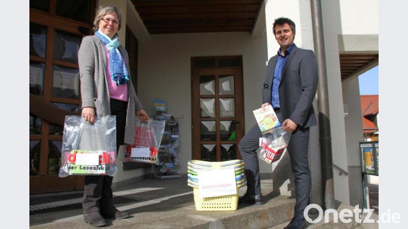 Büchereileiterin Renate Stigler und Bürgermeister Rudolf Teplitzky zeigen, wie die Medienausgabe in der Stadtbücherei kontaktlos funktioniert. Lesestoff, Spiele und Co. werden in Tüten gepackt und können beim Oberviechtacher Rathaus abgeholt werden. Bild: mp