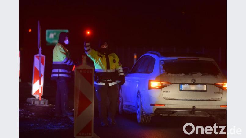 Polizisten kontrollieren nach Mitternacht Autofahrer an einem Kontrollpunkt auf der Autobahn D6 in der Region Karlsbad nach einem Regierungsbeschluss zur Abriegelung der Bezirke Cheb und Sokolov wegen der raschen Ausbreitung des Coronavirus. Bild: Slavomír Kubeš/CTK/dpa