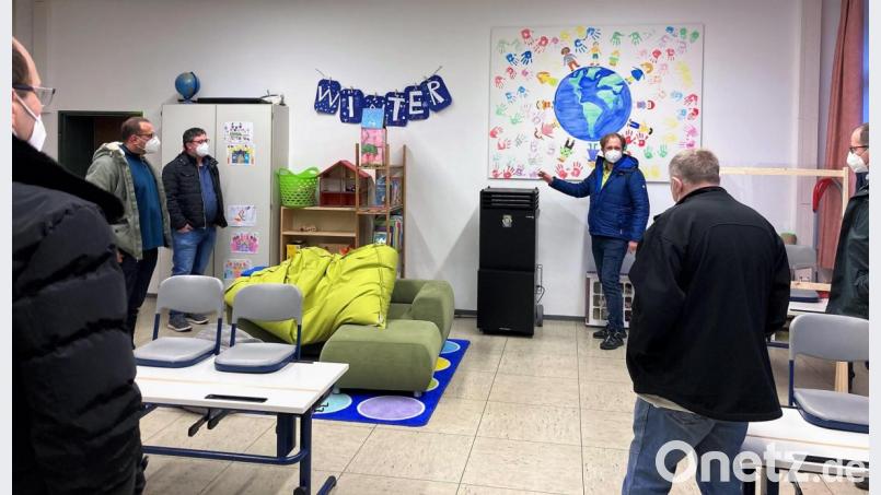 Hausmeister Marco Kiele (Dritter von rechts) erläuterte den Mitgliedern des Bauausschusses in einem Klassenzimmer die Funktionsweise des Raumluftreinigers. Bild: stg
