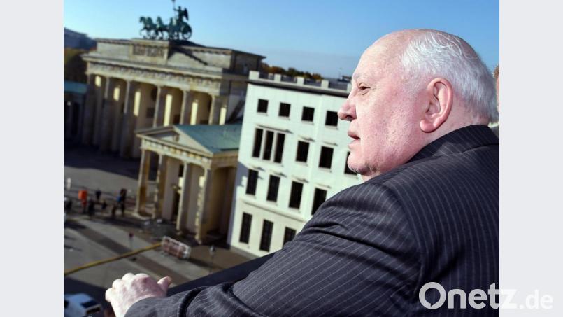 Der frühere sowjetische Staatspräsident Michail Gorbatschow steht am 8. November 2014 am Pariser Platz in Berlin mit Blick auf das Brandenburger Tor. Bild: Jens Kalaene