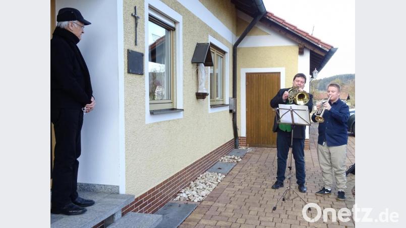 Glückwunsch vor der Haustür und mit Corona-bedingtem Abstand: Auf ihren Blechinstrumenten spielten Bürgermeister Christian Ziegler und sein Sohn Luis dem Ruhestandsgeistlichen Hans Schächtl (links) ein Ständchen zum 80. Geburtstag. Bild: Houschka