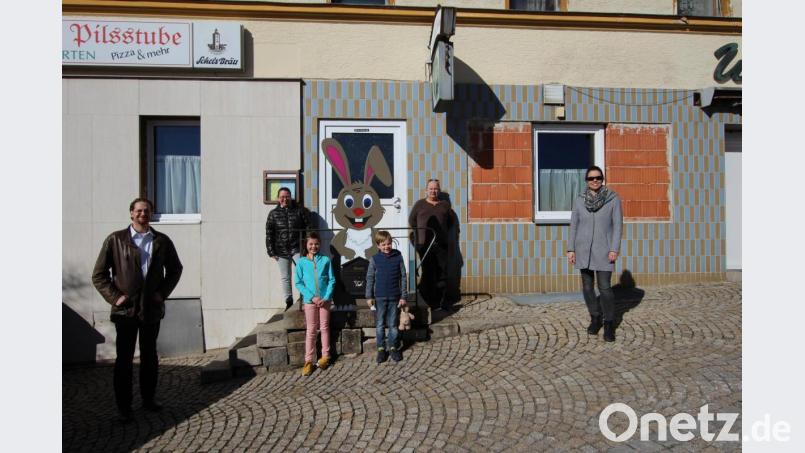 Vor „Murphy´s Pilsstube“ hängt der Osterhasen-Briefkasten, in den bis zum 31. März die Kunstwerke eingeworfen werden können; im Bild der Zweite Bürgermeister Holger Bannert, Andrea Egner, Anna und Ludwig Wünsche, Hans-Peter „Murphy“ Gruber, Pamela Wünsche (von links). Bild: Eichl