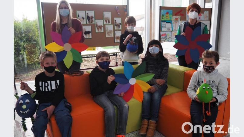 Einige Schüler des Offenen Ganztags präsentierten mit ihren pädagogischen Betreuerinnen Claudia Neumann (hinten, links) und Christiane Landgraf (hinten, rechts) ihre Meisterwerke, die während der Mittagsbetreuung angefertigt wurden, und testeten gleich die neue Sitzgruppe. Bild: jpl