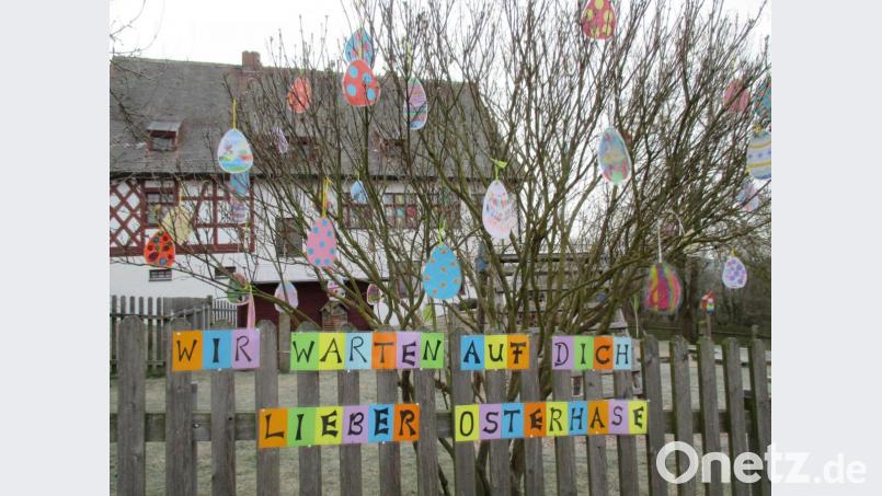 Die bunt bemalten Papiereier am Frühlingsstrauch sowie ein farbenfroher Hinweis am Gartenzaun sollen den Osterhasen aufs Kinderhaus Tillenzwerge aufmerksam machen. Bild: Kinderhaus Bad Neualbenreuth/exb
