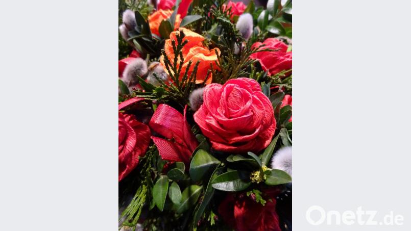 Liebevoll gebunden: Rote Rosen aus Krepppapier und Schleifchen zieren den Palmbuschen – neben Palmkätzchen und allerlei Grün. Bild: ads