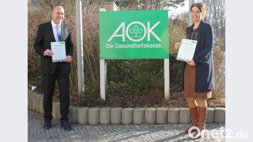 AOK-Direktor Volker Schödel übergibt stellvertretend für alle teilnehmenden Schulen die Patenurkunden an die Leiterin der Dreifaltigkeitsgrundschule, Marion Ott Bild: AOK/Schmidt/exb