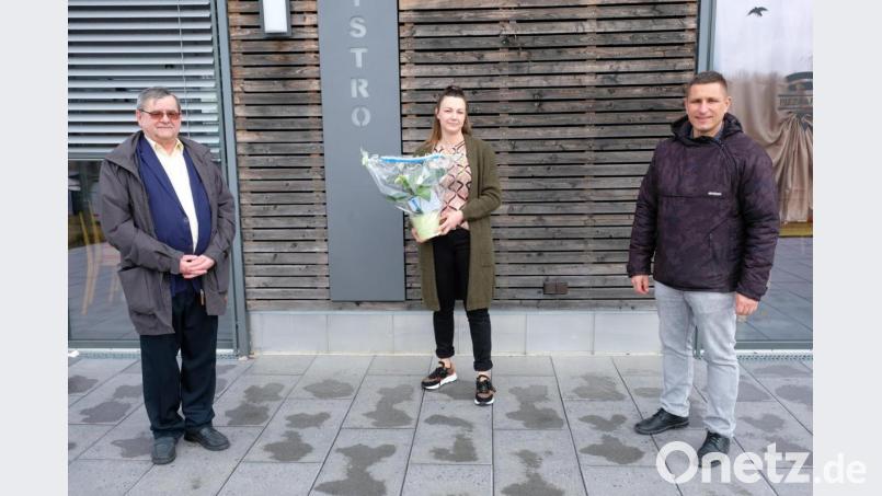 Frühlingserwachen am Hexenhäusl. Voraussichtlich am 1. April 2021 beginnt mit der Verpachtung an Anja Schreglmann eine neue und erfolgreiche Ära am Rußweiherstrand. Das hoffen auch Bürgermeister Marcus Gradl (rechts) und Stadtverbandsvorsitzender Dieter Kies, die schon einmal mit Blumengrüßen die Betriebsleiterin vorstellten Bild: do