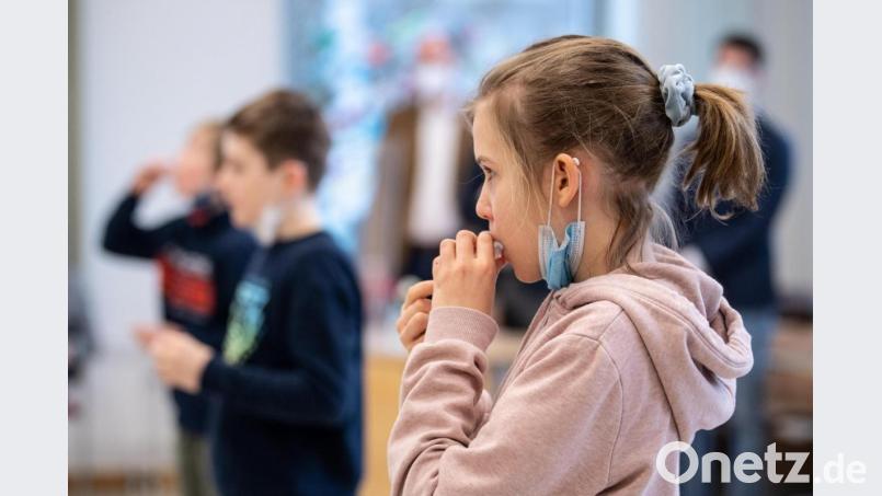 Luise (10 Jahre), Schülerin einer vierten Klasse einer Grundschule, gibt während eines selbst durchgeführten Coronatests ihre Speichelprobe in ein Teströhrchen. Für den Corona-Selbsttest, der als PCR-Test von einem Labor ausgewertet wird, nehmen die Schüler für einige Sekunden ein Watte-Röhrchen in den Mund, das sich während dieser Zeit mit Speichel vollsaugt. Der bayerischen Kultusminister Piazolo (Freie Wähler) und der bayerische Gesundheitsminister Holetschek (CSU) besuchen die Grundschule, um sich die Umsetzung der Corona-Teststrategie anzuschauen. Bild: Matthias Balk/dpa