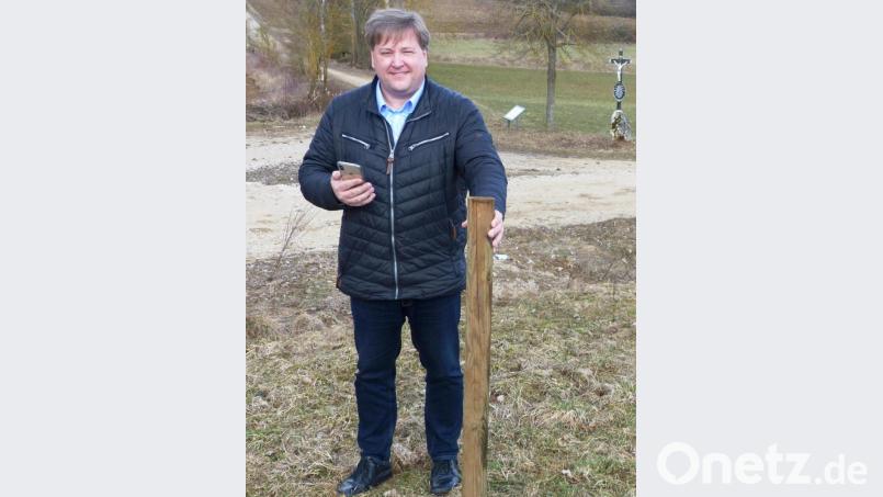 Bürgermeister Stefan Braun markiert mit einem Pfahl den Standort des Funkgittermastes der Telekom auf der Wiese neben dem Dornerweg zwischen Utzenhofen und Mühlhausen. Bild: jp