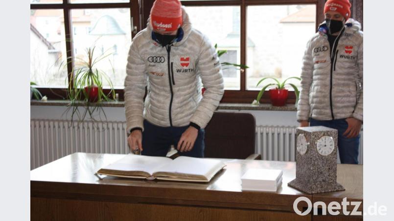 Terence Weber und Eric Frenzel unterschreiben im Goldenen Buch der Gemeinde Flossenbürg. Bild: ui