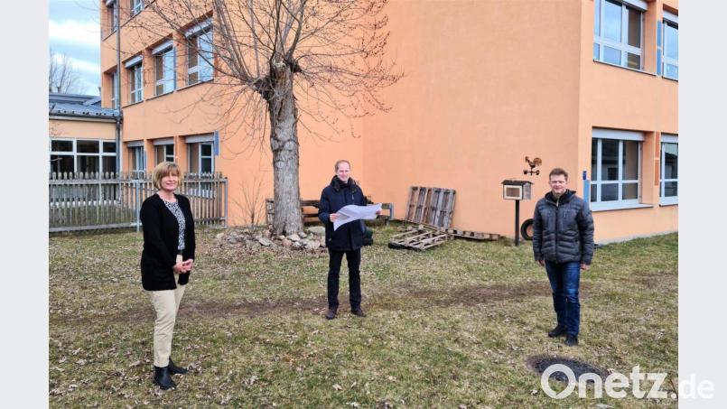Schulleiterin Diana Neidhardt, Bürgermeister Konrad Kiener und Wolfgang Geitner (von links) an der künftigen Baustelle. Die linken Fenster im Erdgeschoss zeigen die künftige Mensa, in der Ecke entsteht ein Anbau für die Essensausgabe und hinter den Fenstern rechts wird die Küche mit Eingang eingebaut werden. Bild: twi
