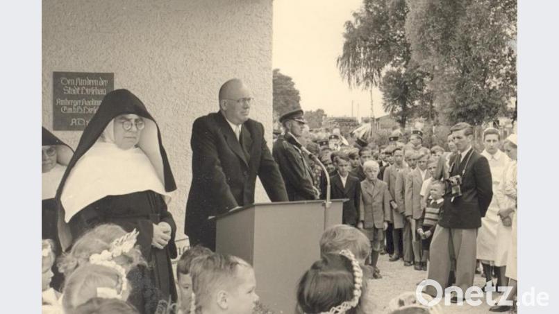 Als der von AKW-Direktor Wolfgang Droßbach (am Rednerpult) gestiftete St.-Wolfgang-Kindergarten am 28. Juni 1953 eingeweiht wurde, berichtete selbst die Wochenschau über dieses Ereignis. Im Bild links: Schwester Celsina Schaller, die erste Leiterin. Im Bild rechts: AZ-Reporter Anderl Müller. Bild: u