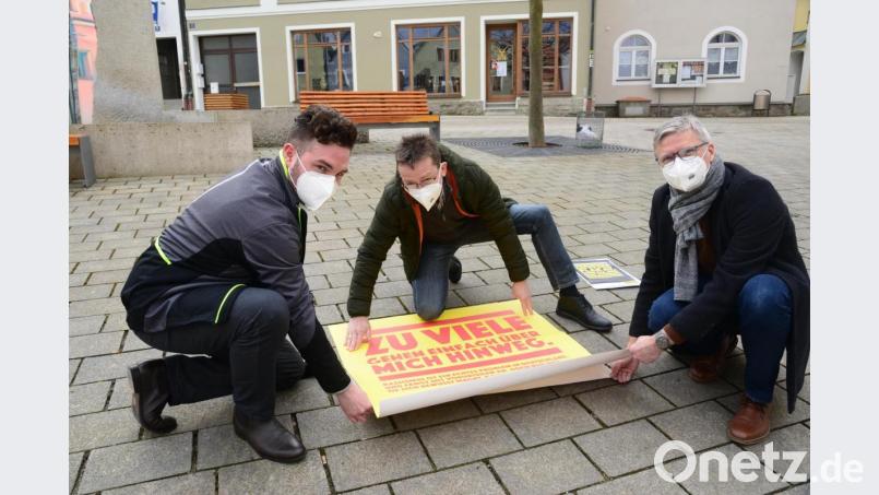 Gemeinsam befestigen Bürgermeister Sebastian Dippold, Martin Neumann, Geschäftsführer des Kreisugendrings und Arno Speiser, Koordinierungs- und Fachstelle &quot;Neustadt lebt Demokratie&quot; einen Bodenaufkleber vor dem Neustädter Rathaus. Bild: bey