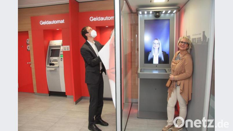 Nach dem erfolgreichen Probelauf mit Ines Wildenauer (rechts) und Franziska Hackl am anderen Ende der Internetleitung entfernte Filialleiter Joachim Walter (links) die "Schutzhülle" am neuen Service-Terminal der Wiesauer Sparkasse. Bild: wro