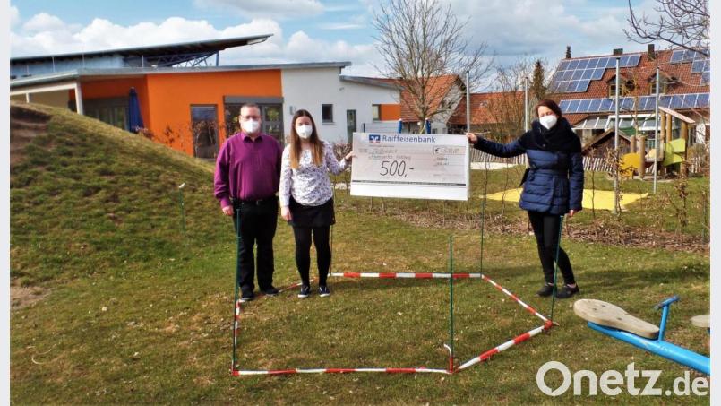 Stefan Kurz und Tochter Susanne Scheuerer übergeben an Leiterin Marion Eitel (rechts) einen Scheck über 500 Euro als Grundstock. Damit soll für den Kindergarten Arche Noach im mit Trassierband abgesteckten Bereich ein neues Klettergerät gekauft werden Bild: jml