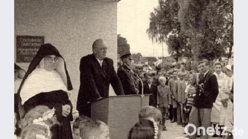 Als der von AKW-Direktor Wolfgang Droßbach (am Rednerpult) gestiftete St.-Wolfgang-Kindergarten am 28. Juni 1953 eingeweiht wurde, berichtete selbst die Wochenschau über dieses Ereignis. Im Bild links: Schwester Celsina Schaller, die erste Leiterin. Im Bild rechts: AZ-Reporter Anderl Müller. Bild: u