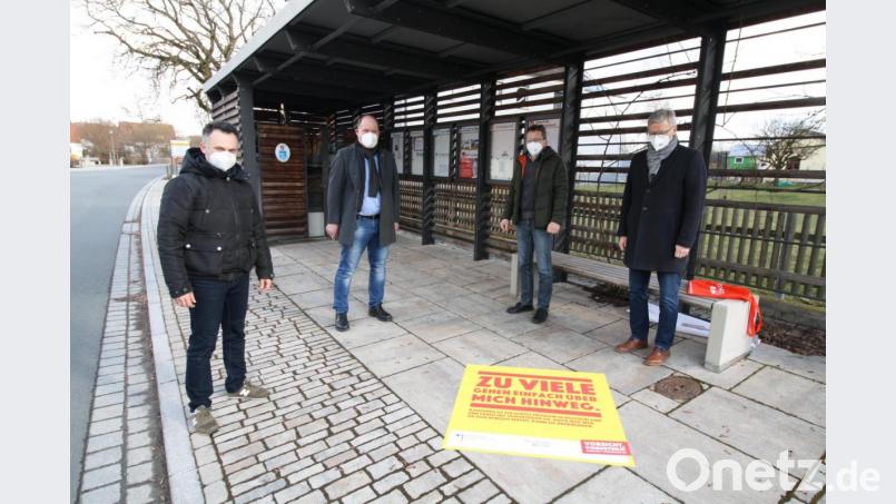 Nur wer sich Vorurteile bewusst macht, kann sie überwinden: Diesen Denkanstoß gibt der Bodenaufkleber, Andreas Kick, der Jugendbeauftragte der Gemeinde Schwarzenbach, Bürgermeister Thorsten Hallmann, Kreisjugendring-Geschäftsführer Martin Neumann und „Neustadt lebt Demokratie“-Koordinator Arno Speiser (von links) zum &quot;Aktionstag gegen Alltagsrassismus&quot; beim Bushäuschen am Dorfplatz anbringen. Bild: bjp