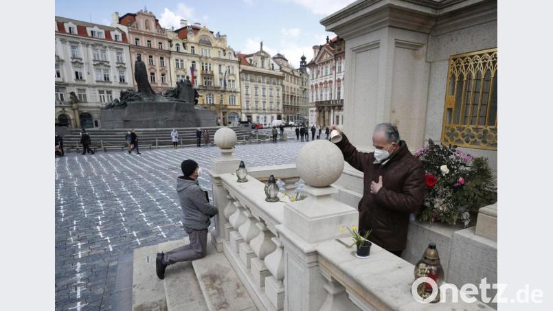 Menschen nehmen an einer Schweigeminute auf dem Altstädter Ring in Prag teil, um ein Jahr nach Beginn der Corona-Pandemie den Opfern zu gedenken. Bild: Petr David Josek/dpa