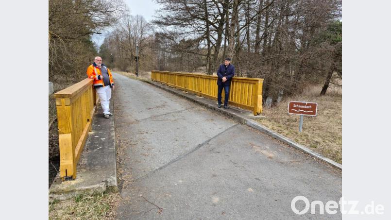 Bürgermeister Edgar Knobloch (rechts) und Klaus Guthmann lehnen an dem neuen Geländer schon mal Probe. Das Werk des Bauhofs sollte wieder einige Jahrzehnte Sicherheit auf der Schaumbachbrücke geben. Bild: sne