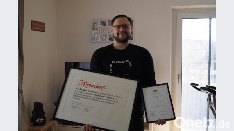 Stolz präsentiert der neue Zahntechniker-Meister Sebastian Guttenberger den Meisterbrief und den Meisterpreis der Bayerischen Staatsregierung. Bild: du