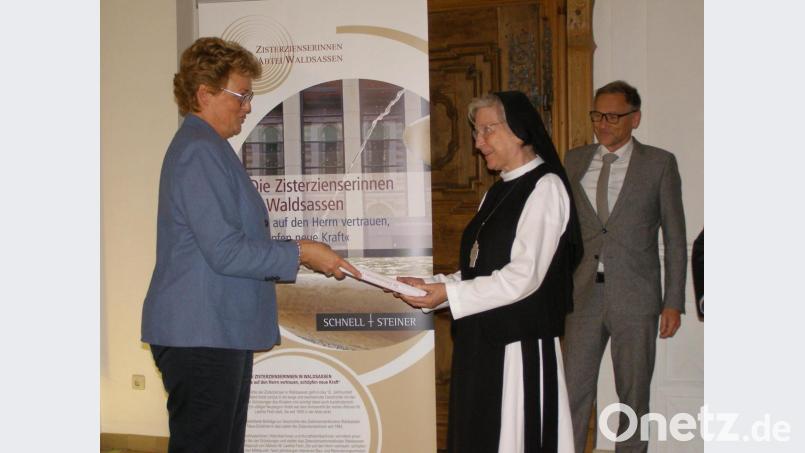 Das erste Exemplar des neuen Buches, das als eine Art Festschrift zum 25. Jahrestag der Weihe von Sr. M. Laetitia zur Äbtissin erschienen ist, überreichte Klosterfreunde-Vorsitzende Monika Hohlmeier an die Chefin des Klosters. Rechts Bürgermeister und Zweiter Förderkreis-Vorsitzender Bernd Sommer. Bild: pz