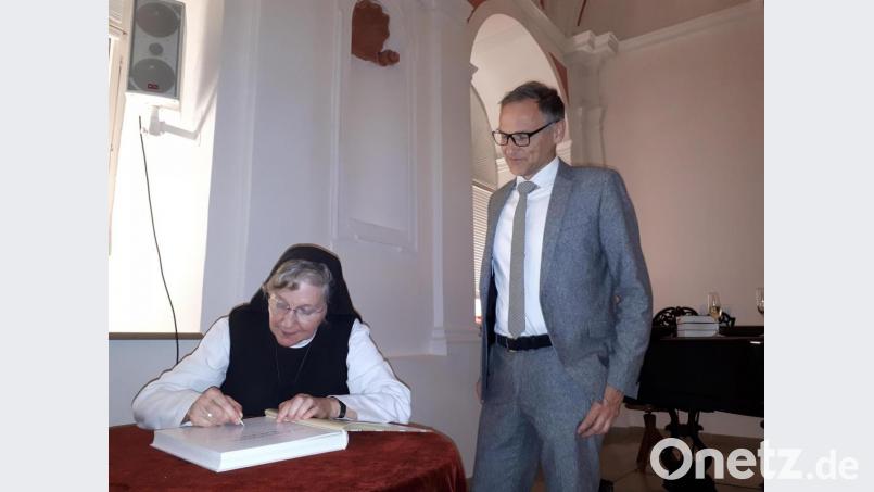 Nach dem offiziellen Teil musste Äbtissin Laetitia Fech viele der neuen Bücher signieren, darunter auch das von Bürgermeister Bernd Sommer. Bild: pz