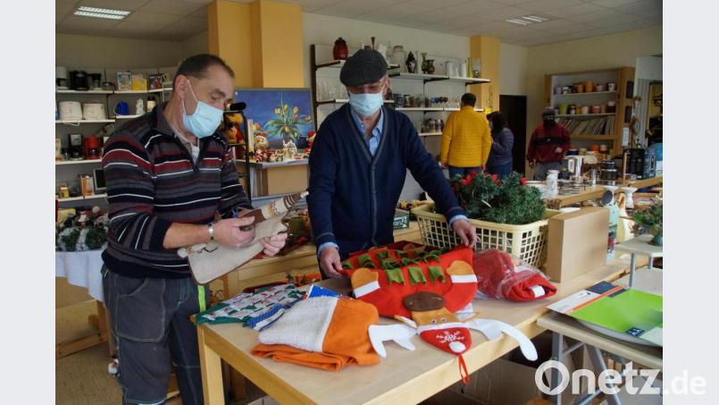 Peter Kett und Erich Steiner (von links) bestücken im Werkhof Tirschenreuth einen Verkaufstisch mit Weihnachtsartikeln. Bild: kaz