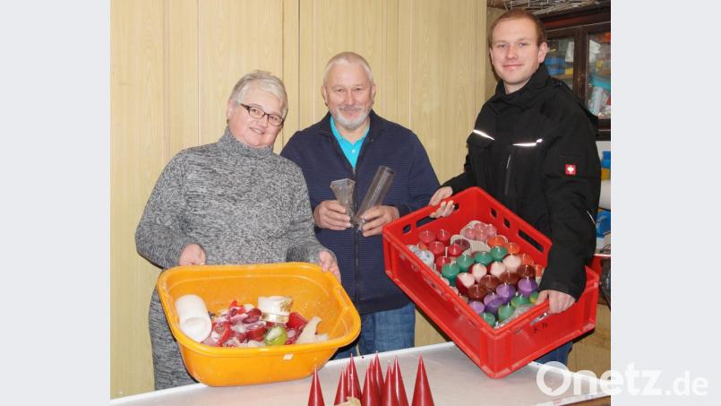 Aus Wachsresten macht Winfried Reymann (Mitte) neue Kerzen. Ehefrau Petra und Sohn Jens helfen beim Verkauf. Bild: kaz