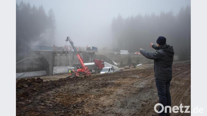 Baudirektor Gerhard Kederer vom Staatlichen Bauamt Amberg-Sulzbach zeigt, wie die neue Straße der B299 einmal verlaufen wird. Auf dem Bild ist die zweite Brücke zu sehen. Arbeiter bereiten diese gerade für den Winter vor. Bild: lue
