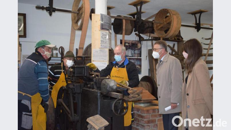 Herbert Konrad (rechts) bedient die Daubenbiegemaschine. Diese bringt die Fasshölzer mit hohem Druck in Form, Spannklammern halten die Holzstücke solange fest, bis sie abgekühlt und getrocknet ist. Bild: szl