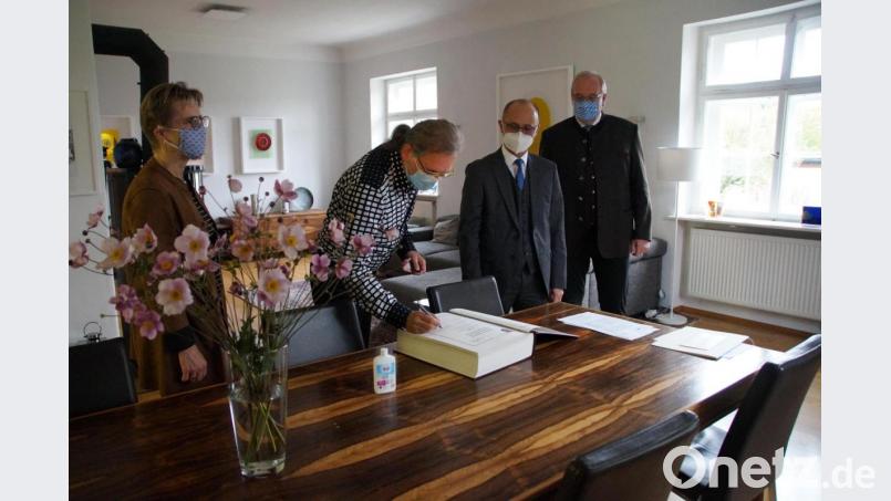 Bernhard Dagner darf sich im Goldenen Buch der Gemeinde Kümmersbruck eintragen. Bild: kaz