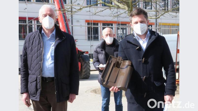 Aufsichtsratsvorsitzender Arnold Kimmerl, Vorstand Ernst Georg Bräutigam und Bürgermeister Peter Neumeier (von links) zeigen einen der Aufdachhalter, an denen die Solarmodule befestigt werden. Bild: Hirsch