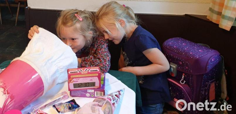 Nach der Schule geht es zum gemeinsamen Essen mit der Familie. Schwester Frida (rechts) schaut Lotta über die Schulter und guckt, was so alles in der Schultüte der Erstklässlerin steckt. Unter anderem hat sich die Sechsjährige einen eigenen Wecker gewünscht. Bild: Andreas Rosner/exb