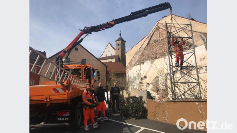 Das Bild kann als Symbol für einen aus dem Stadtbild verschwindenden Schandfleck gelten: Der Bauhof transportierte im Beisein von Bürgermeister Frank Zeitler den Gerüst-Pylon vom Grundstück am Mühlweg 2 ab. Die am Eingang zur Altstadt gelegene Fläche, die auch in Stadtratssitzungen oft in die Kritik geraten war, gehört jetzt der Stadt Nabburg, die Pläne für eine ansprechende Gestaltung machen lässt. Bild: Wilhelm Amann