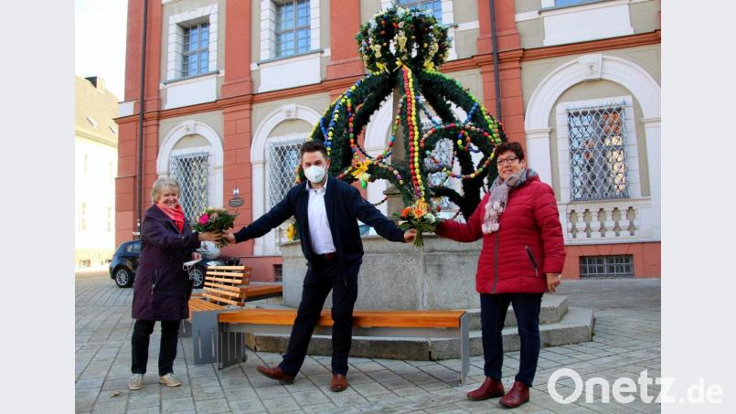 Bürgermeister Sebastian Dippold dankt den Organisatorinnen Gabi Fröhlich (links) und Marianne Lebegern mit einem Sträußchen für ihre Mühen beim Aufstellen des Osterbrunnens in Neustadt. Bild: fsb